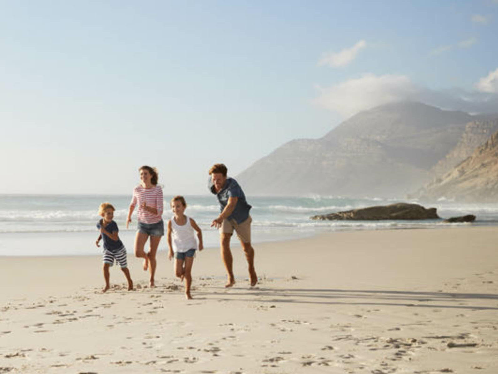 A family running along the beach near hotel Costieres