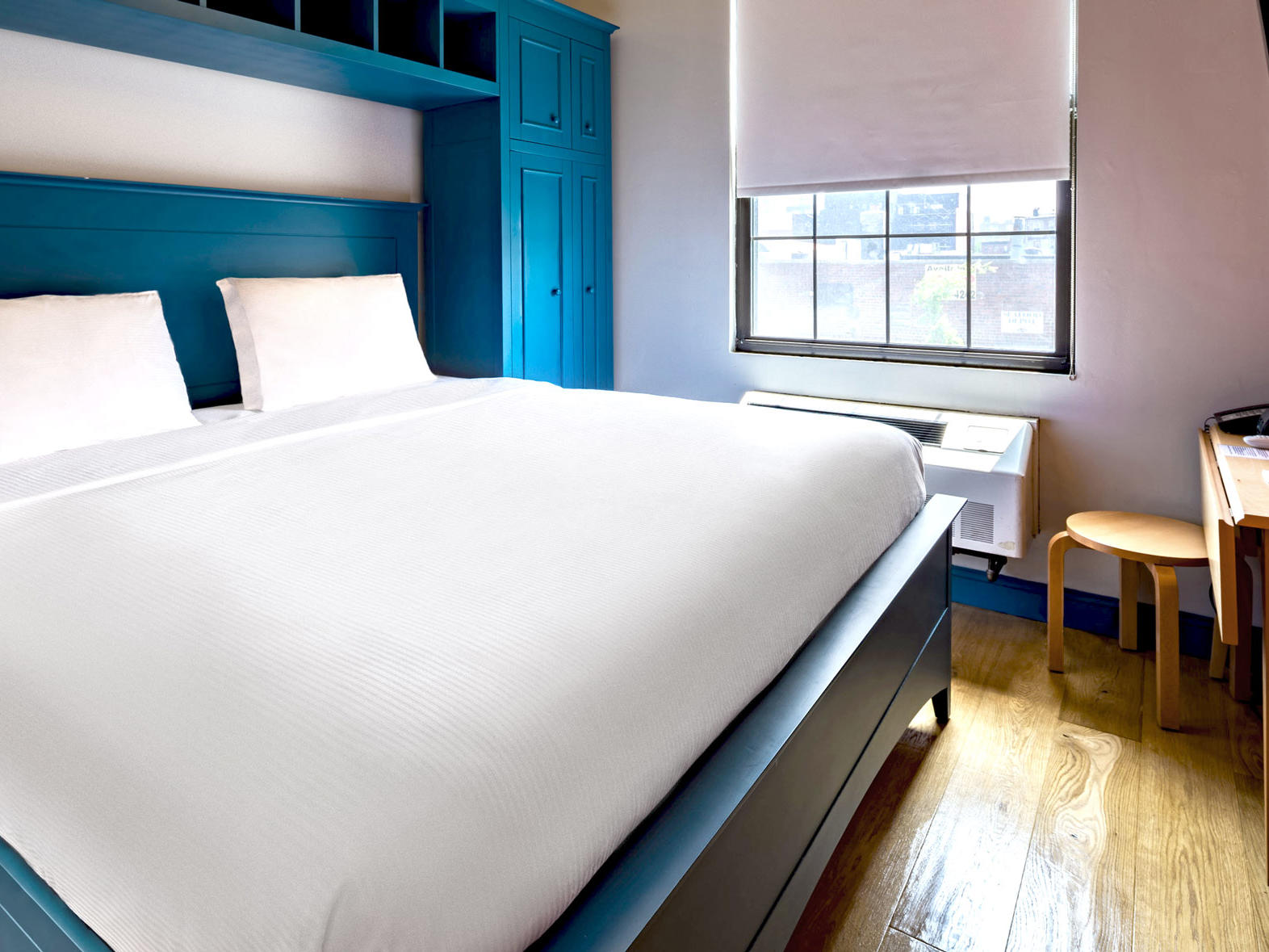 King bed and blue frame in hotel room with window