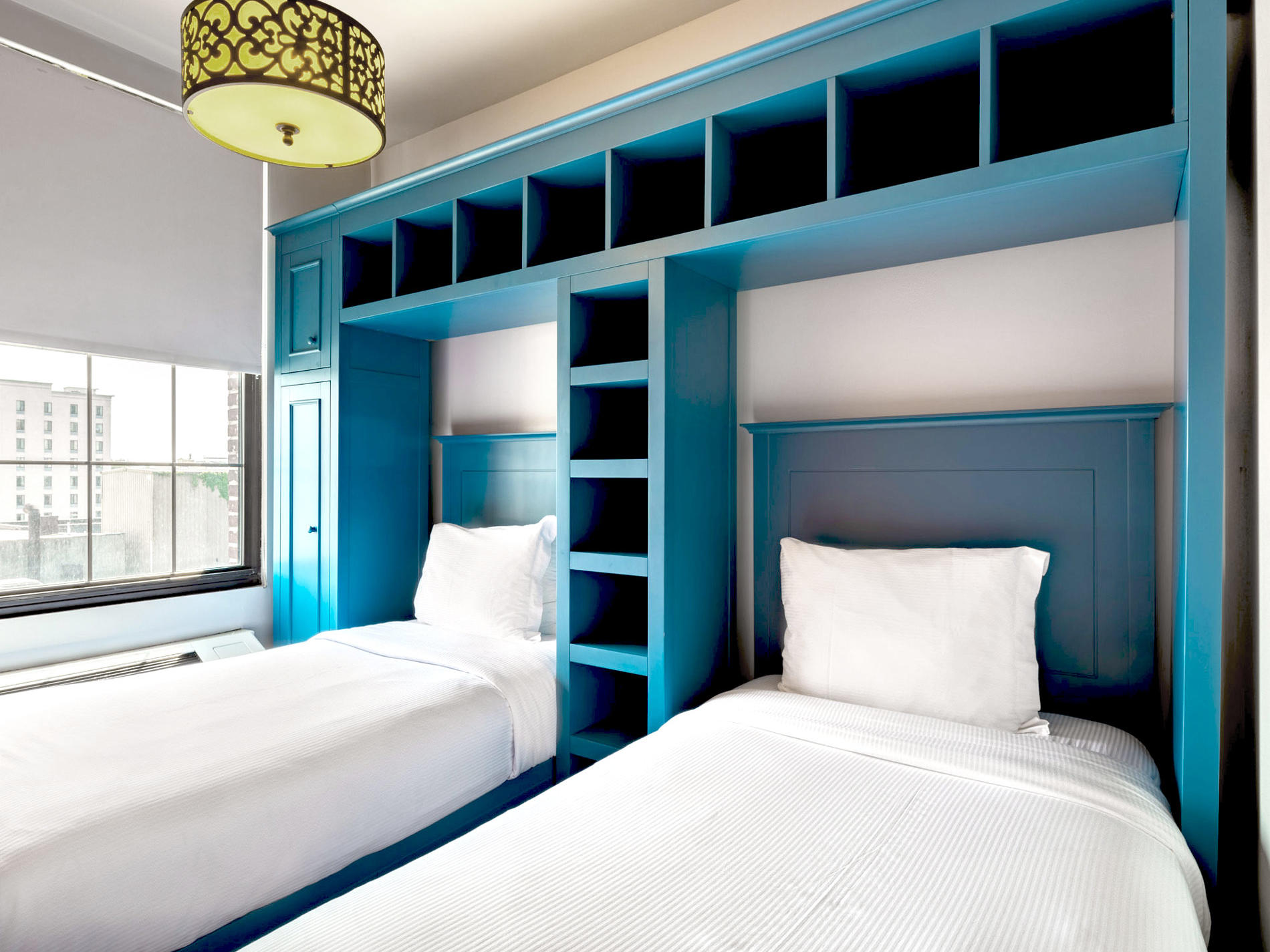 Two twin beds with blue frames and cabinets