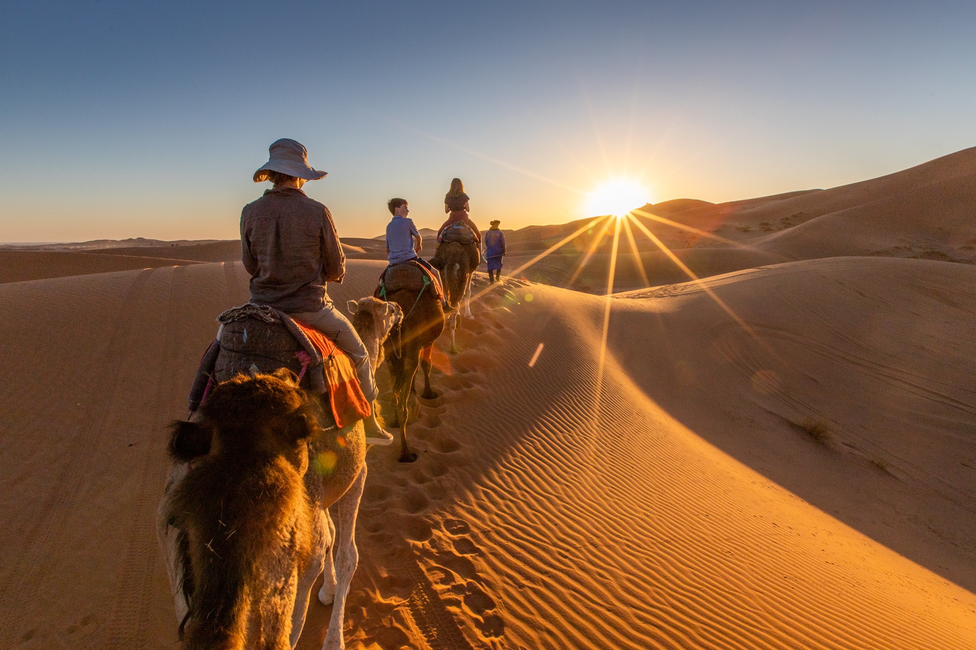 People on camel riding tour in Sahara Desert, Morocco near Fullerton Group