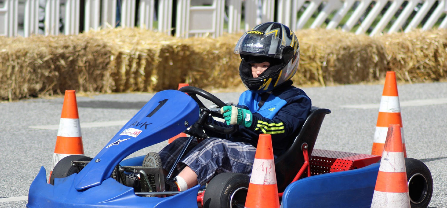kid strapped in a go-kart outside