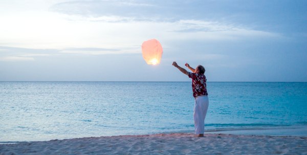 A guy launching a wish lantern at The Somerset On Grace Bay