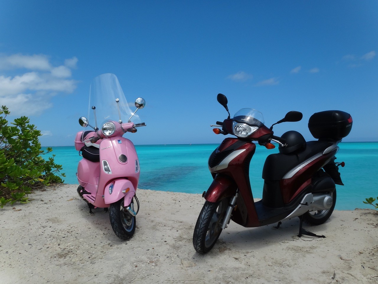 Two scooters parked by the bay near The Somerset on Grace Bay